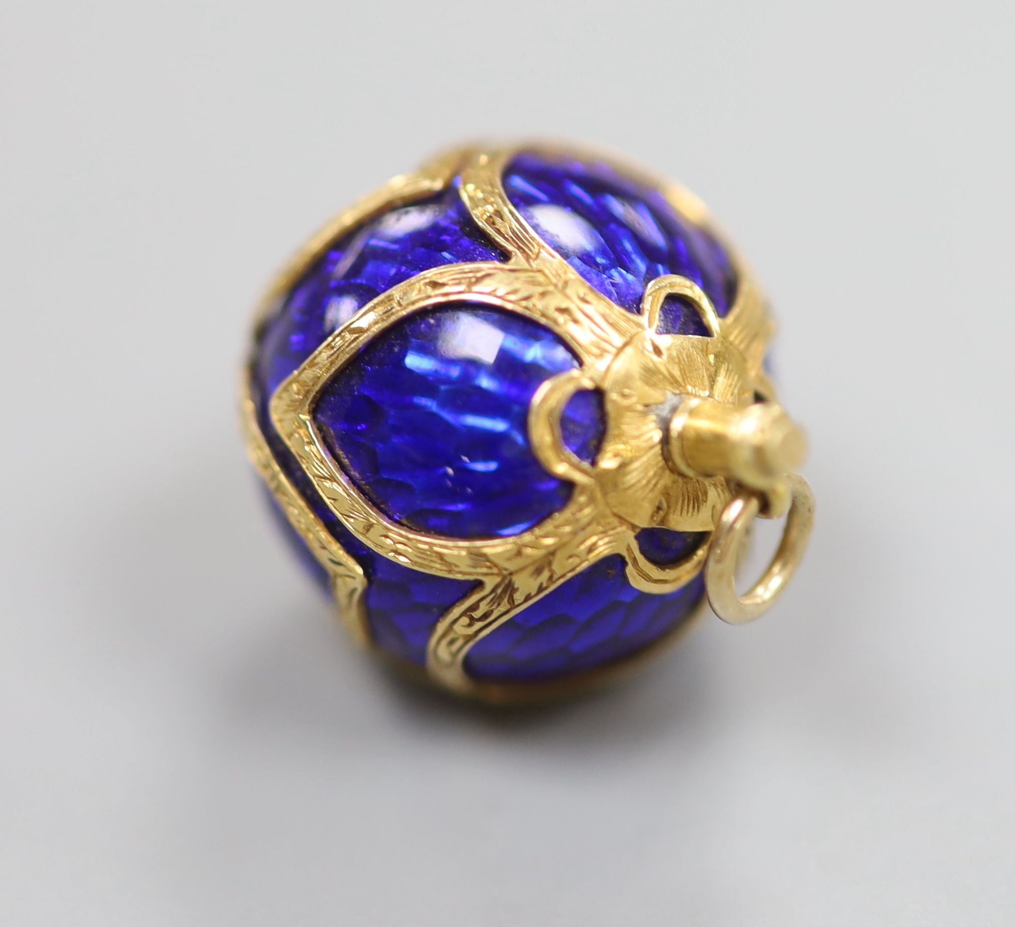 A 19th century engraved yellow metal and blue enamel set sphere pendant, 16mm, gross 7.7 grams.